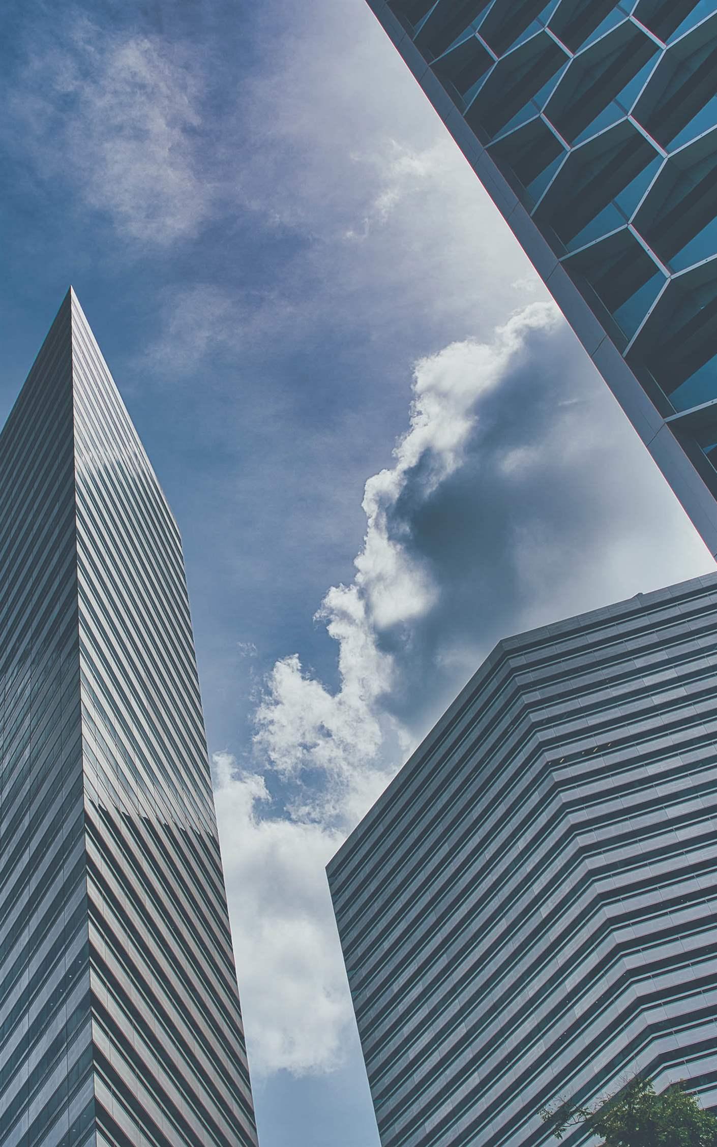 Panoramic and perspective wide angle view to steel light blue background of glass high rise building skyscraper commercial modern city of future.